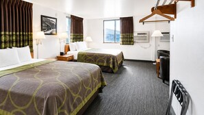 A hotel room with two beds, a desk, a chair, a hanging coat rack, and a window with curtains.