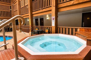Un jacuzzi con cubierta de madera y zona de piscina.