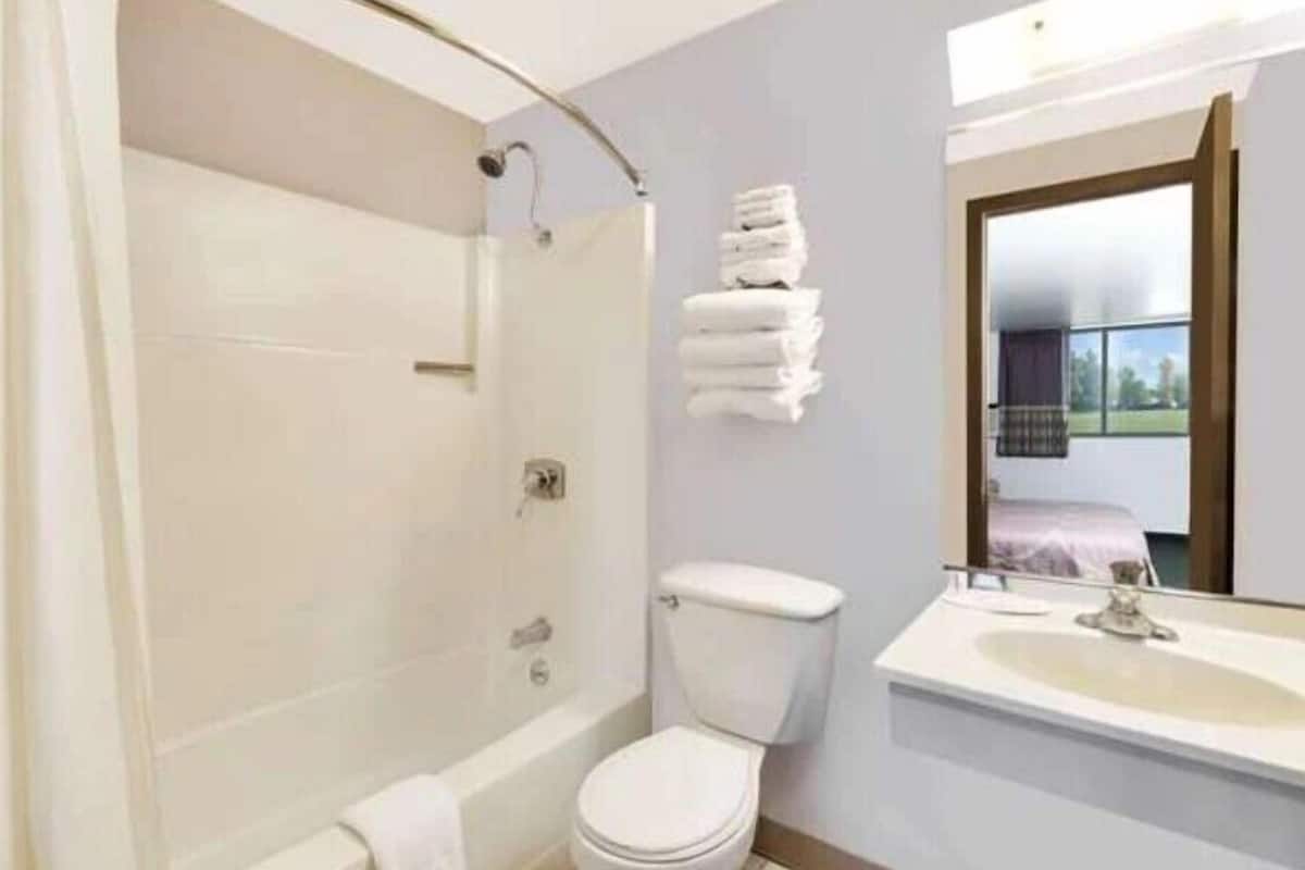 A modern bathroom with a shower, toilet, and sink.