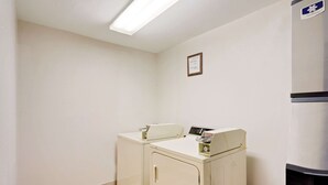 A laundry room with two washing machines and a dryer. - Super 8 by Wyndham Lexington/Hamburg Area (Lexington)
