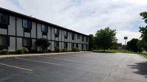 A parking lot with a building that has multiple windows and a sign indicating 'Auburn Town'. - Auburn Inn (Auburn)