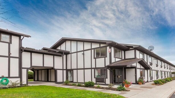 A modern building with a symmetrical facade, multiple windows, and a satellite dish. - Auburn Inn (Auburn)