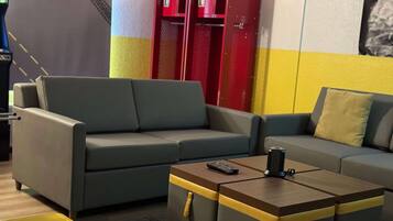 A modern living room with grey sofas, a wooden coffee table, and a red storage unit.