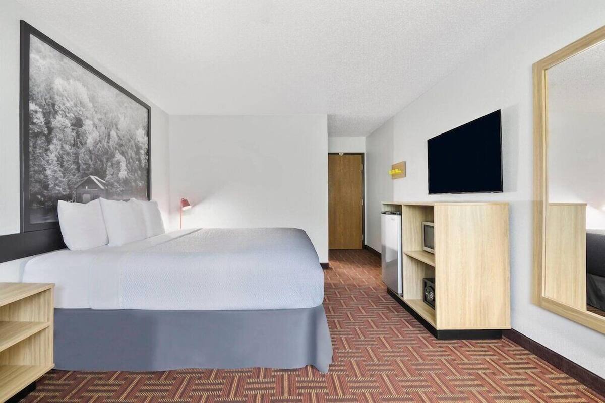 Une chambre d’hôtel équipée d’un lit, d’une télévision, d’un bureau et d’une armoire.
