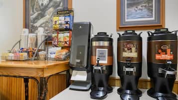 A coffee station with a coffee machine, a hot water dispenser, and a coffee grinder.