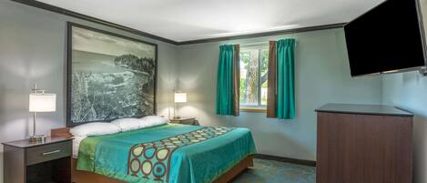A hotel room with a bed, two bedside tables with lamps, a large painting on the wall, a window with curtains, and a flat-screen TV mounted on the wall.