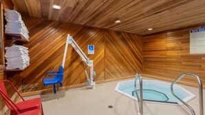 A wooden interior with a pool area, including a hot tub, a blue chair, and a red chair. - Super 8 by Wyndham Duluth (Duluth)