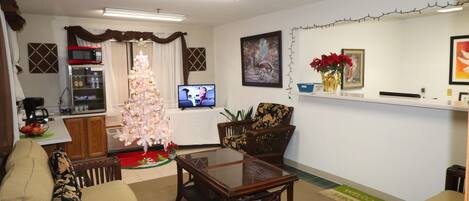 Una sala de estar con un árbol de Navidad, un televisor y una zona de cocina al fondo.
