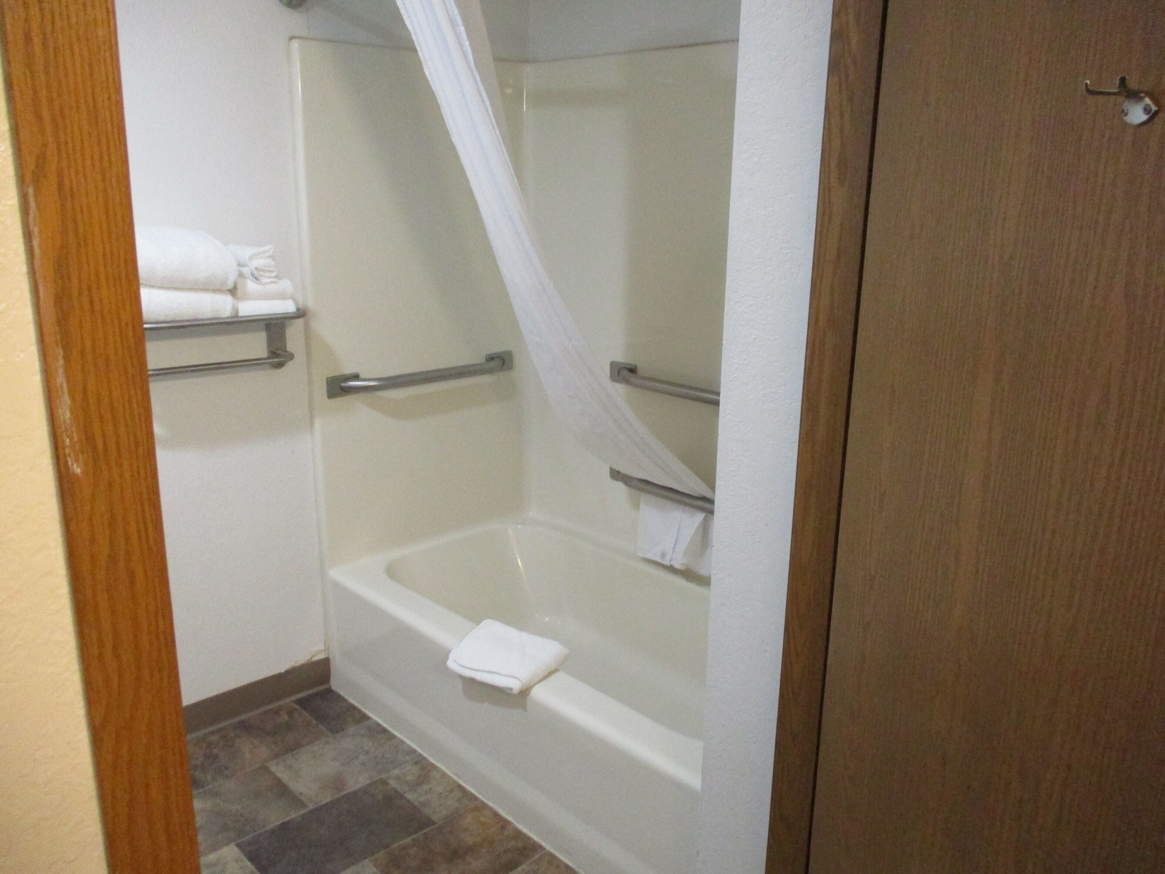 Un baño con ducha de vidrio, bañera y un perchero para toallas.