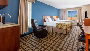 A hotel room with a large bed, a desk, a chair, and a TV. - Baymont by Wyndham Rochester Mayo Clinic Area (Rochester)