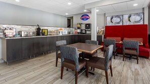 A breakfast corner with a counter, seating area, and a red partition. - Baymont by Wyndham Rochester Mayo Clinic Area (Rochester)