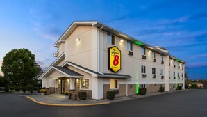 Un hôtel Super 8 au design moderne, caractérisé par une enseigne bien visible, de nombreuses fenêtres et un parking.