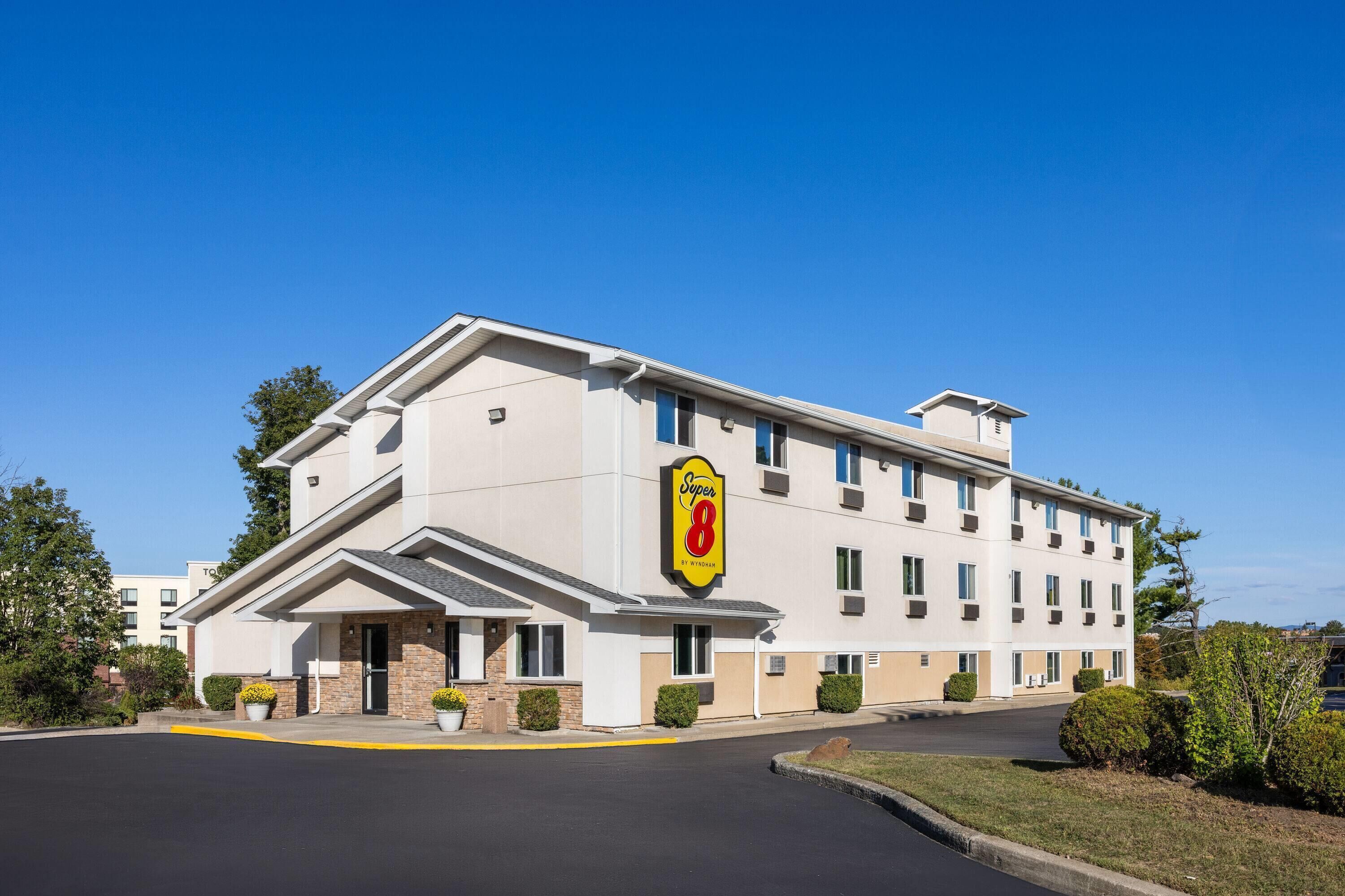 A multi-story hotel with a prominent 'Super 8' sign, a flat roof, and a parking lot in front.