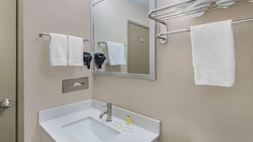 A bathroom with a sink, mirror, towel rack, and a door.
