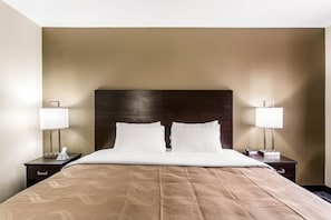 A hotel room with a large bed, two bedside tables, and a headboard. - Quality Inn Salt Lake City Downtown (Salt Lake City)