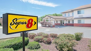 Cartel de motel Super 8, con un estacionamiento y un edificio al fondo.