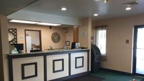 Zona de recepción con mostrador, reloj, cartel de 'no se aceptan devoluciones en efectivo' y detector de incendios.