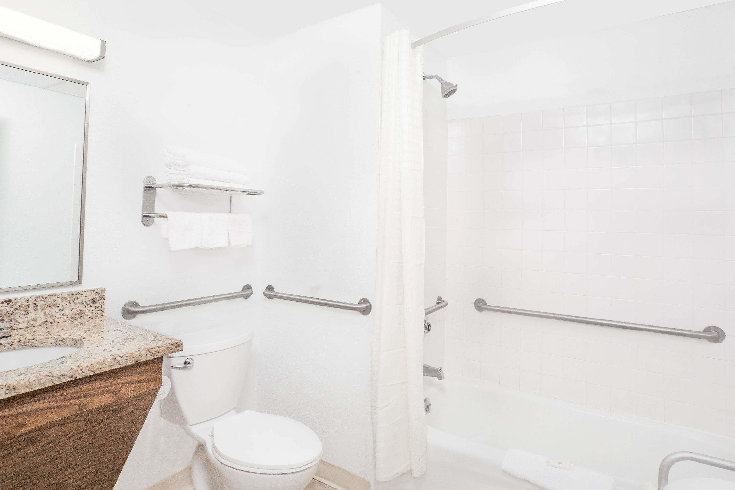 A modern bathroom with a toilet, sink, and shower area.