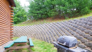 A wooden cabin with a picnic table and a barbecue grill. - Super 8 by Wyndham Lake George/Warrensburg Area (Lake George)