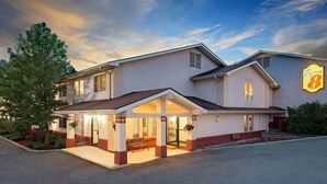 A hotel with a covered entrance, outdoor seating, and a Super 8 logo. - Super 8 by Wyndham Newburgh/West Point Near Stewart Airport (Newburgh)