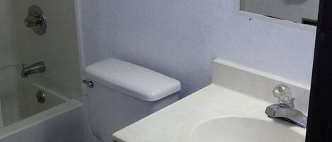 A bathroom with a toilet, a sink, and a bathtub.