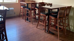 A dining area with a ceiling fan, wooden chairs, a table, and a window with curtains. - Super 8 by Wyndham Newburgh/West Point Near Stewart Airport (Newburgh)