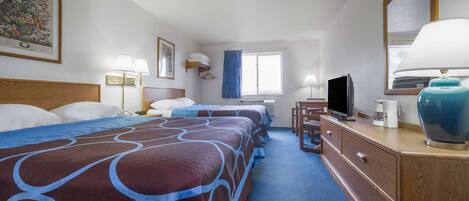 Une chambre d’hôtel avec deux lits, une télévision, une commode et une fenêtre avec des rideaux.