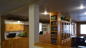 Una zona de recepción con armarios de madera, un mostrador y una estantería.