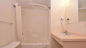 A bathroom with a shower, a sink, a towel rack, and a mirror.