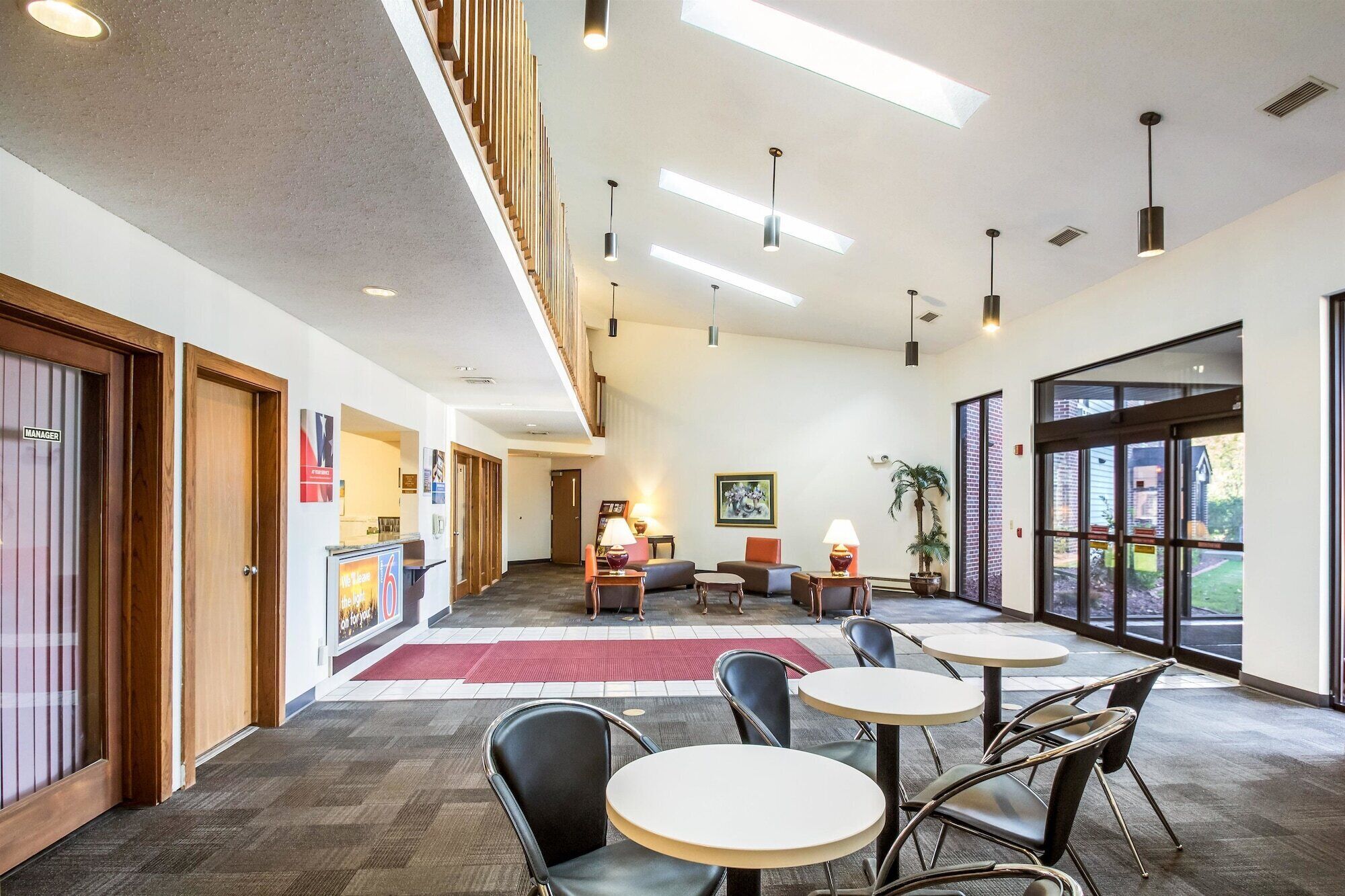 A spacious lobby with a high ceiling, multiple seating areas, and large windows providing natural light.
