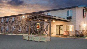 Un hotel con fachada de ladrillo, un acceso cubierto y un letrero que indica que es un Super 8.
