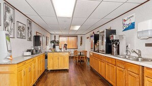 Cocina con armarios de madera, una isla central y un refrigerador.