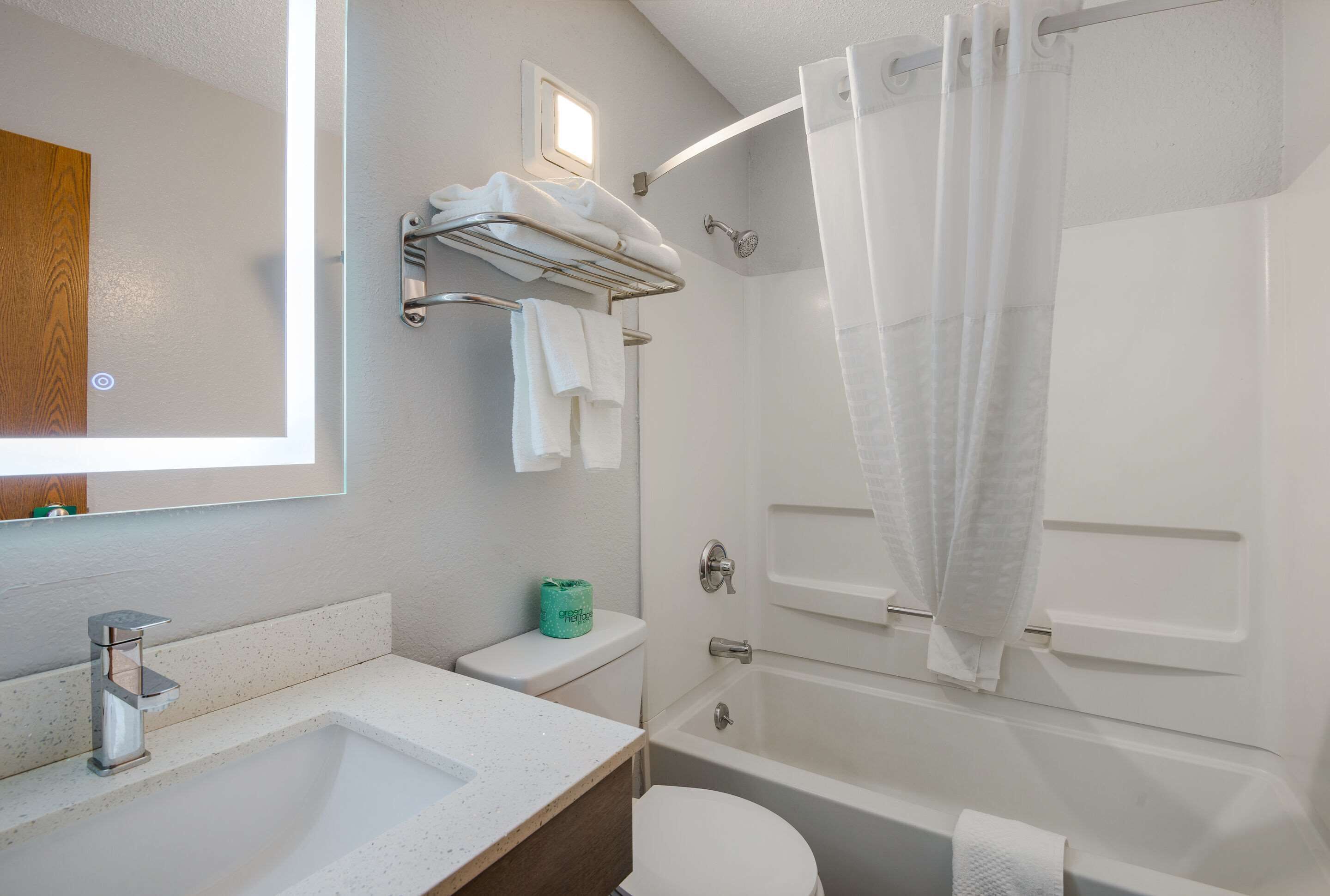 Ein modernes Badezimmer mit Waschbecken, Toilette und Badewanne.