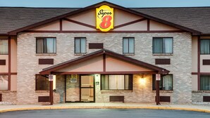 Un hotel Super 8 con fachada de ladrillo, un llamativo letrero de 'Super 8' y un acceso cubierto.