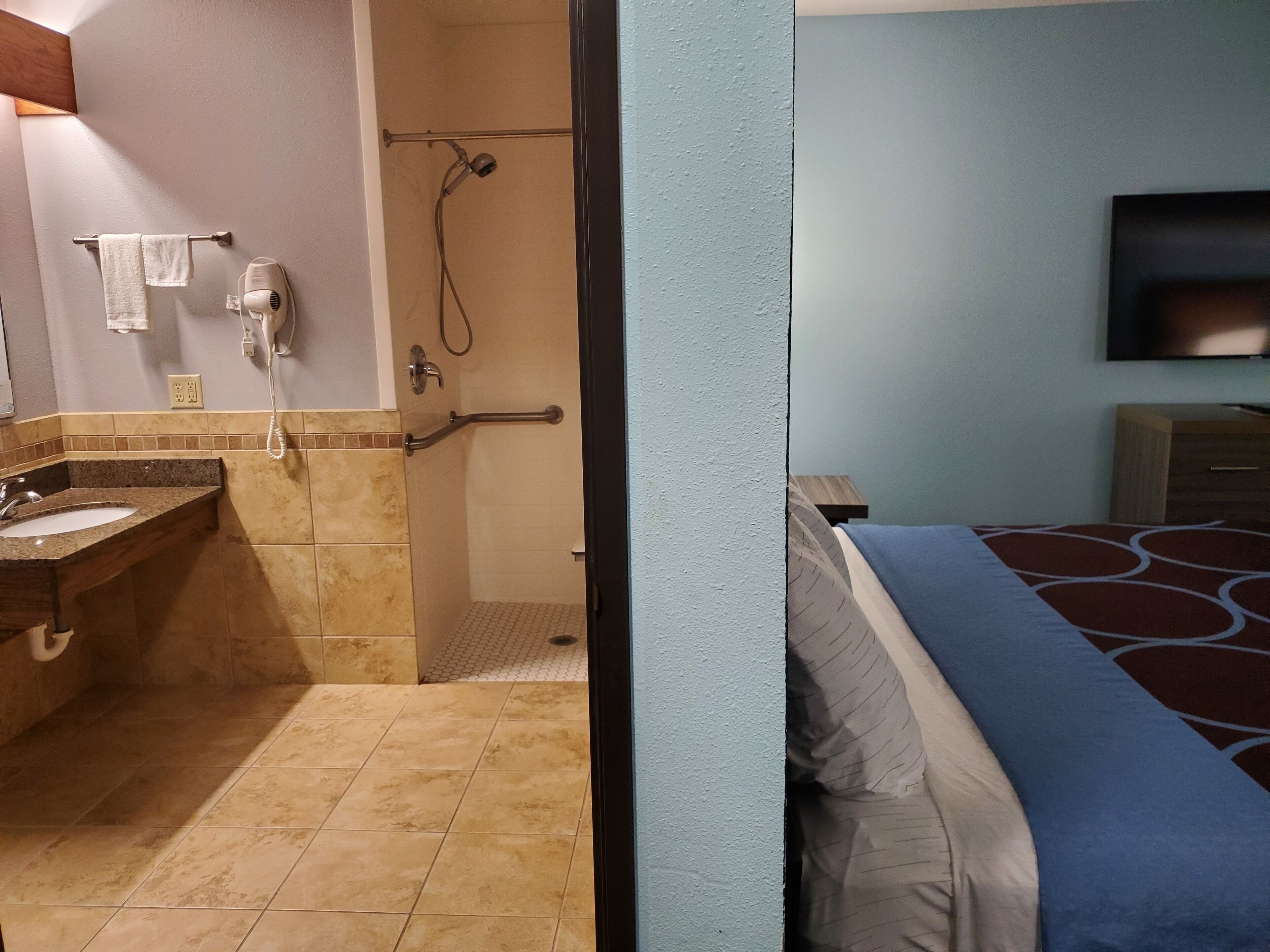 Une salle de bain équipée d’un lavabo, d’un porte-serviettes et d’une douche avec un pommeau de douche amovible.