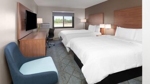 Une chambre d’hôtel avec deux lits, un bureau, une chaise, une télévision et un appareil de climatisation.
