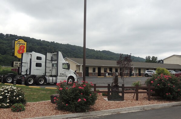 Un motel con una camioneta grande estacionada al frente, un cartel que dice 'Super 8' y un letrero que anuncia el 'Trip Advisor Hall of Fame'.