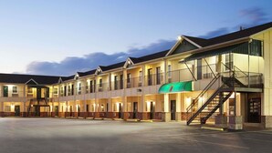 A motel with multiple rooms, a central staircase, and a parking lot. - Super 8 by Wyndham Mifflinville Near Bloomsburg (Mifflinville)