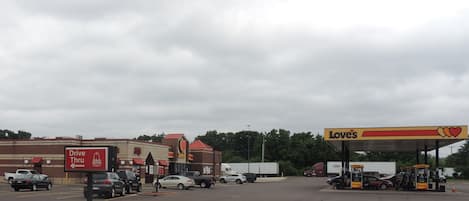 A parking lot with a Loves gas station and a drive-thru for Arby's.