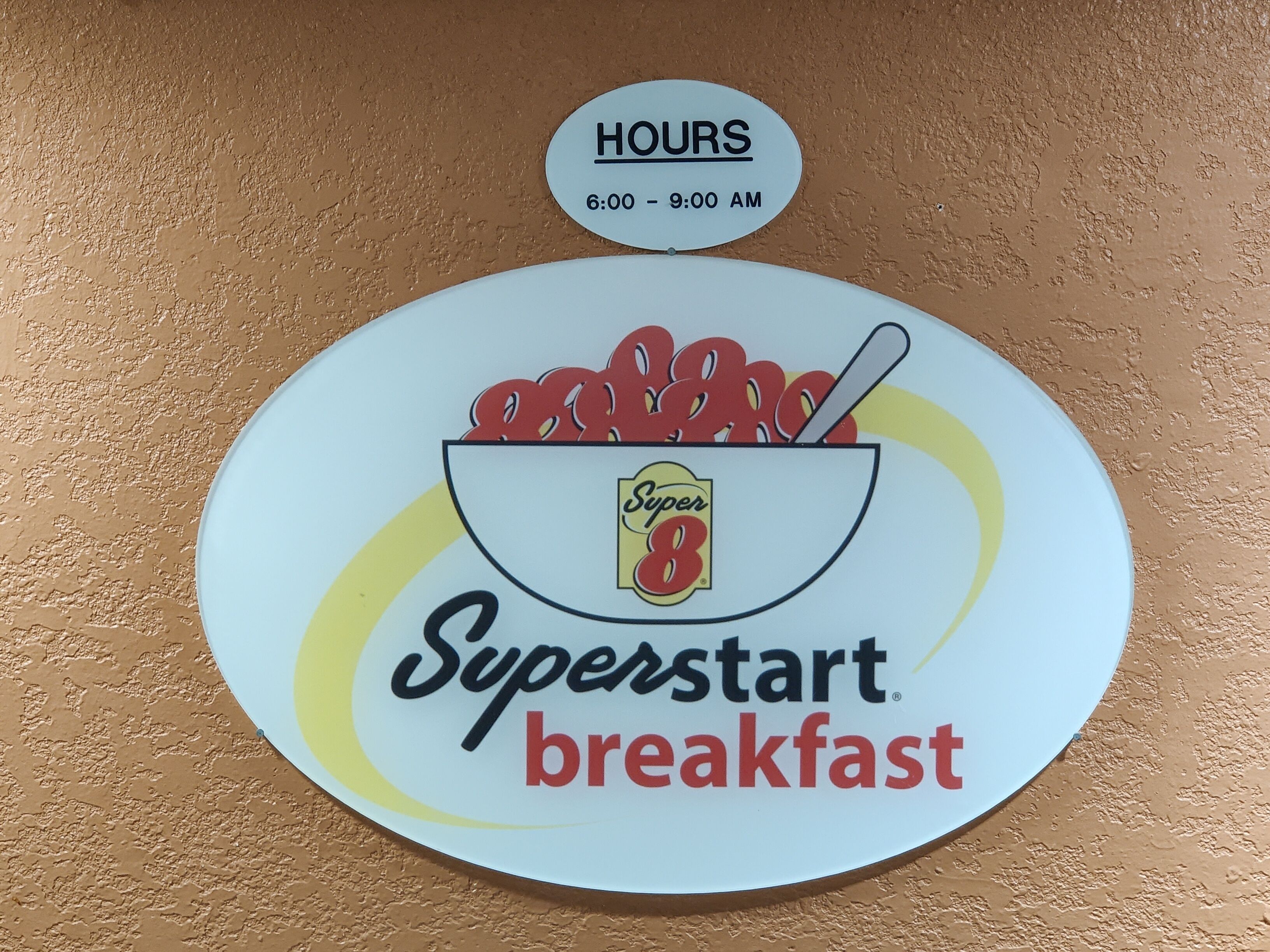 A wall sign for Superstart breakfast with operating hours from 6:00 to 9:00 AM.