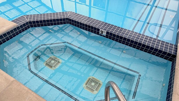 A swimming pool with a 3 FT depth marker, tiled edges, and a metal ladder. - Super 8 by Wyndham Logan (Logan)