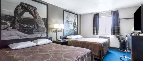 A hotel room with two beds, a desk, a chair, a TV, and a window with curtains.