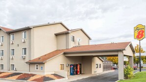 A motel with a flat roof, a covered entrance, and a sign indicating it is a Super 8 motel. - Super 8 by Wyndham Logan (Logan)