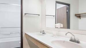 A bathroom with a white sink, a mirror, and a towel rack. - Super 8 by Wyndham Logan (Logan)