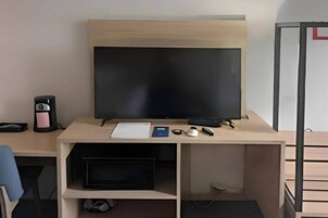 Un escritorio moderno con un monitor de pantalla plana, un teclado, un ratón y un par de gafas.