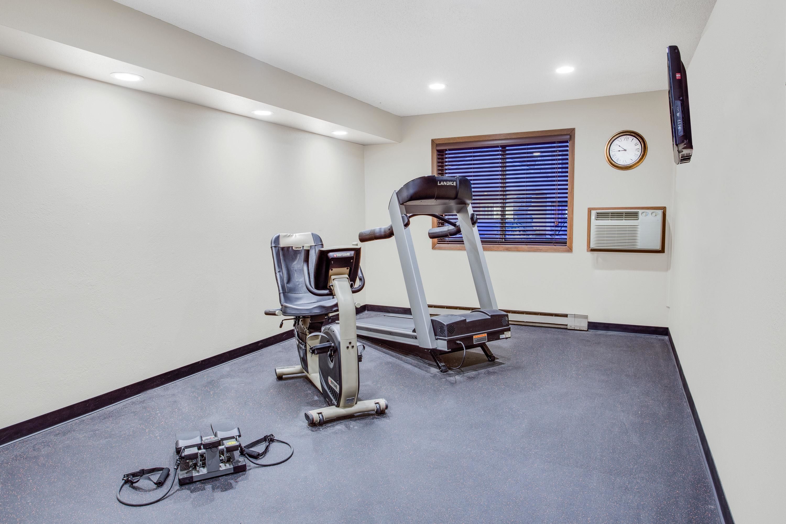 Una palestra con tapis roulant, ellittica e cyclette.