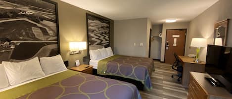 A hotel room with two beds, a desk, a chair, a TV, and a large painting on the wall.