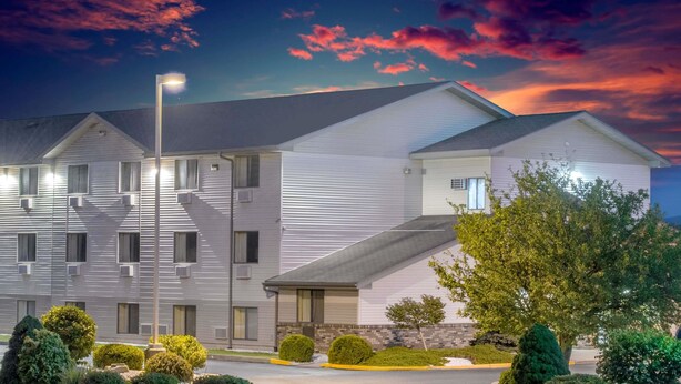 Ein mehrgeschossiges Hotel mit modernem Design, das ein flaches Dach und eine symmetrische Fassade aufweist.
