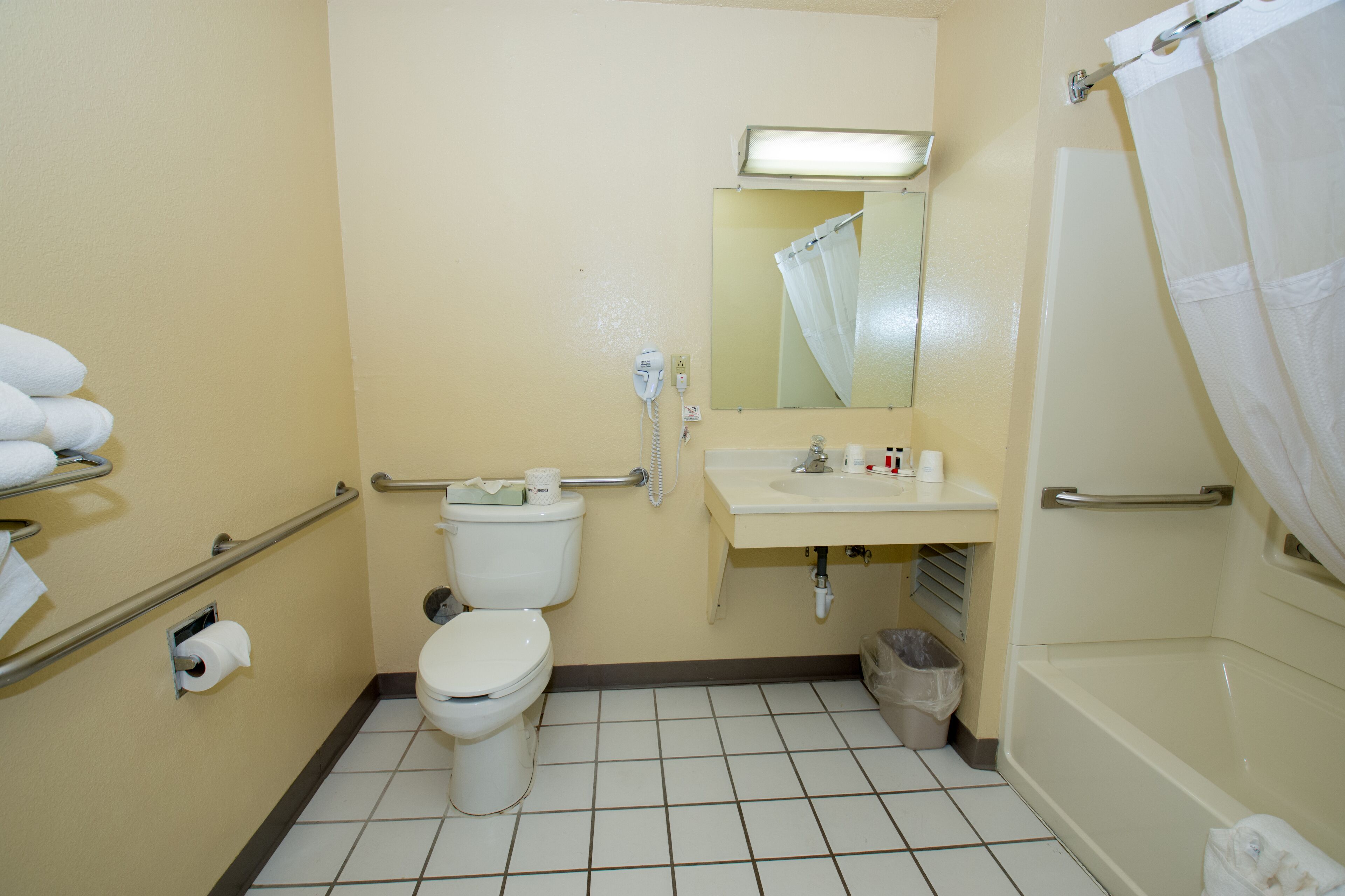 Een kleine, eenvoudige badkamer met toilet, wastafel en douche.