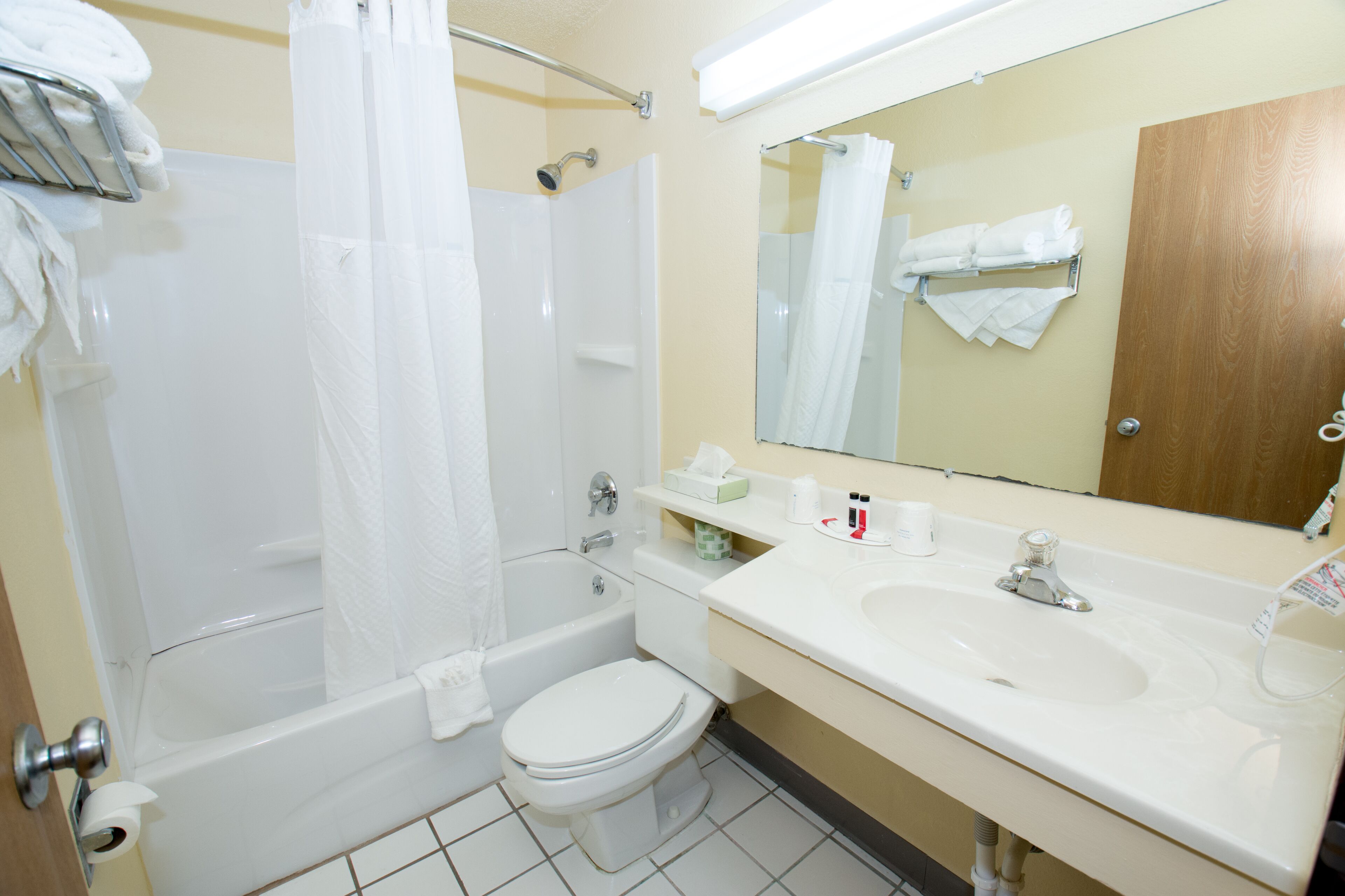 Un baño con bañera, inodoro, lavabo y espejo.